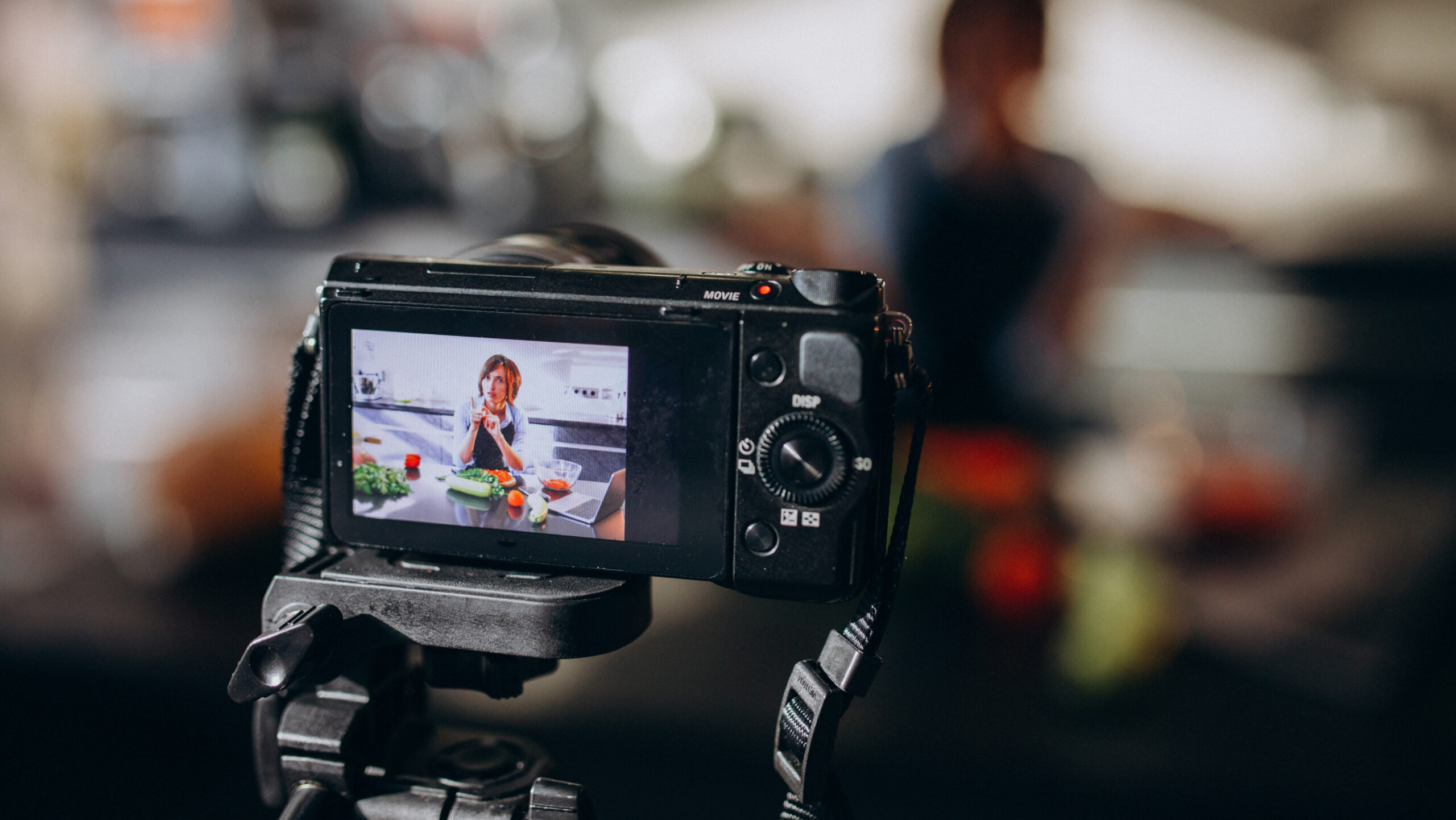 Young woman videoblogger cooking at the kitchen and filming